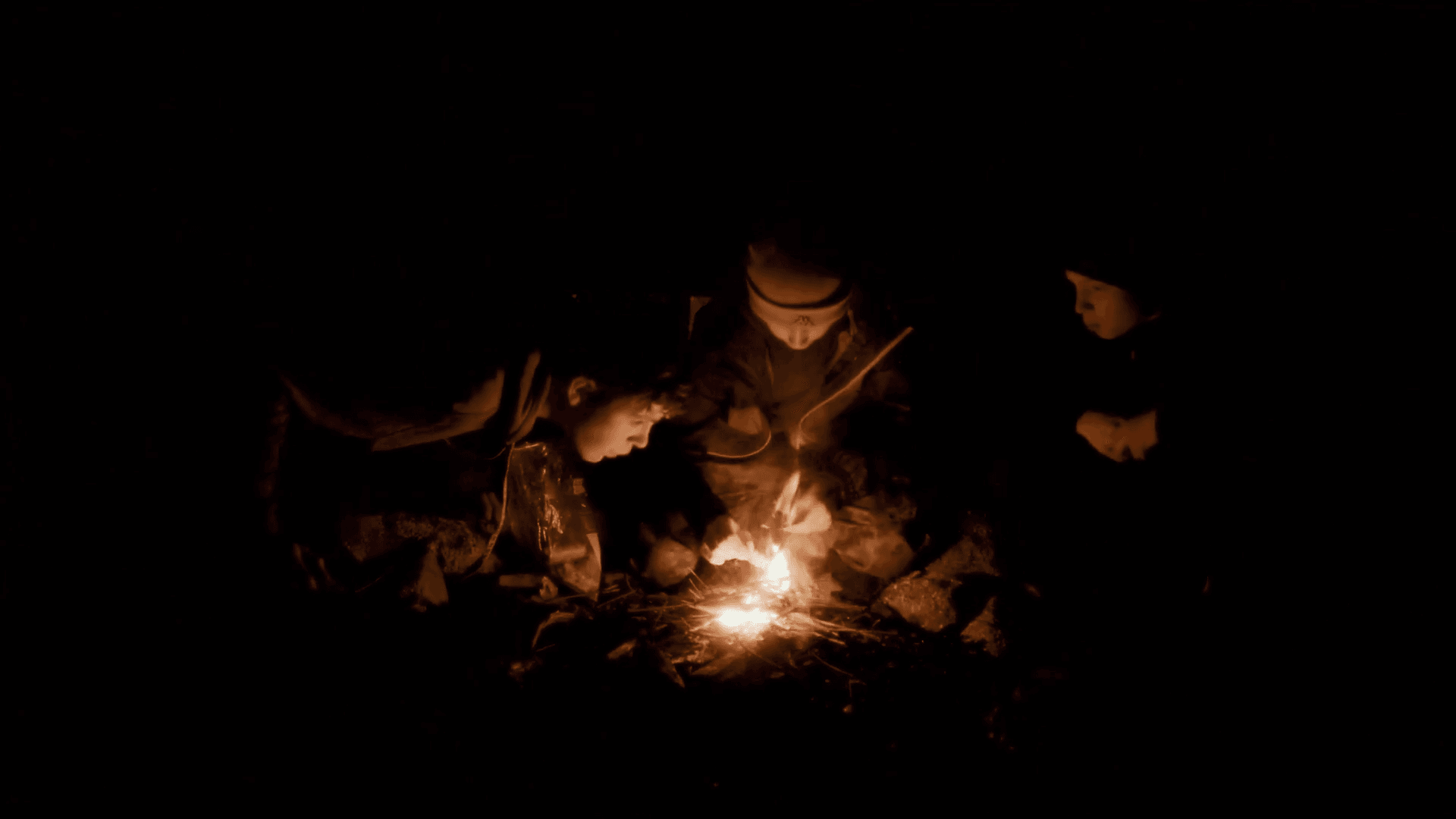 Gruppe sitzt am Lagerfeuer und reflektiert den Tag
