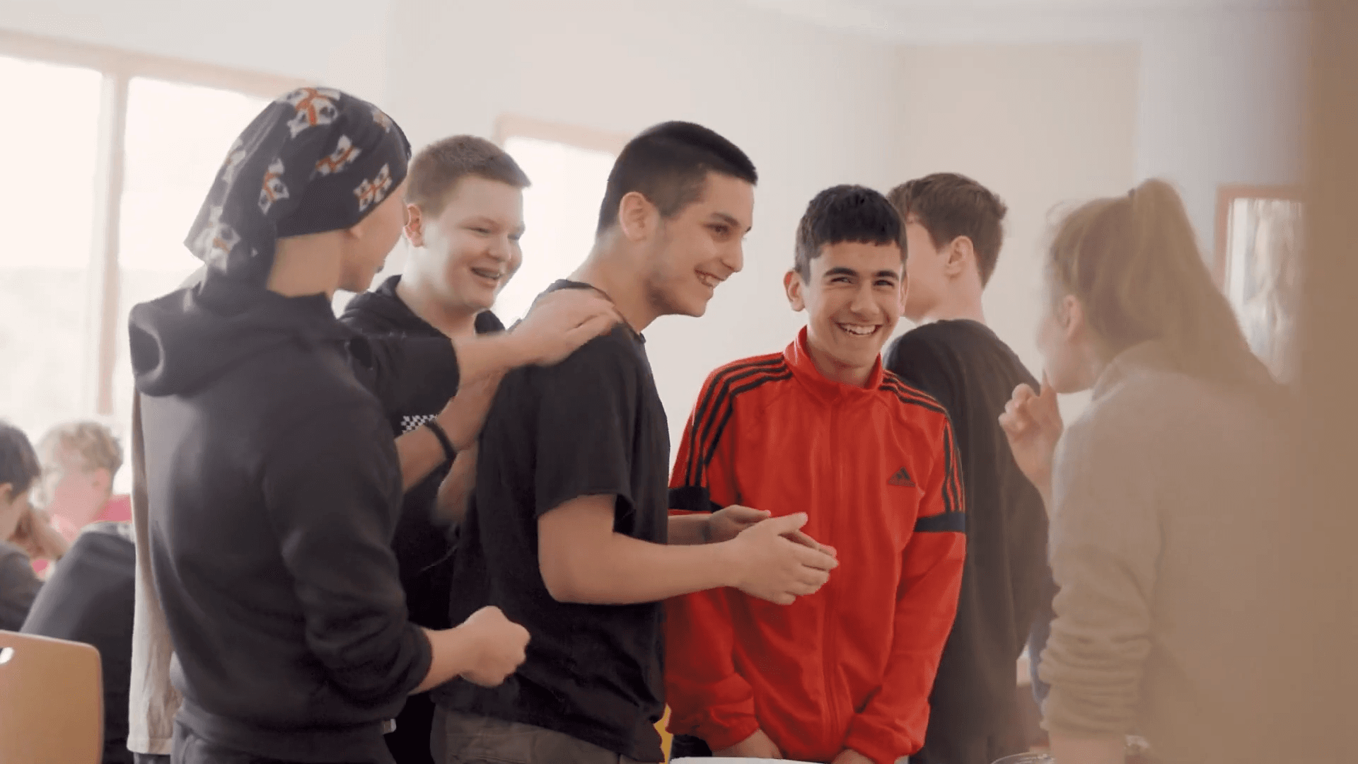 Jugendliche lachen gemeinsam in der Küche des Gruppenhauses